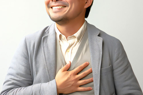 胸に手を当てる男性